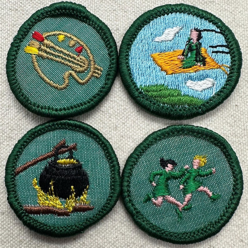 Puede incluir: Cuatro parches bordados con bordes verdes. Los dise&ntilde;os incluyen un paseo en alfombra m&aacute;gica, una olla sobre un fuego, un haz de flechas y dos figuras corriendo. Cada parche presenta costuras detalladas sobre un fondo verde azulado.