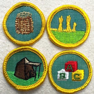 May include: Four embroidered patches with a teal background and gold trim. The patches depict a woven basket, wheat stalks, a tent, and alphabet blocks. The patches are likely for a youth organization.