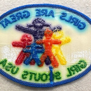 May include: Embroidered patch with a blue border and the text "GIRLS ARE GREAT" and "STUDENTS ARE US". The patch features five colourful figures in red, blue, orange, yellow, and purple.