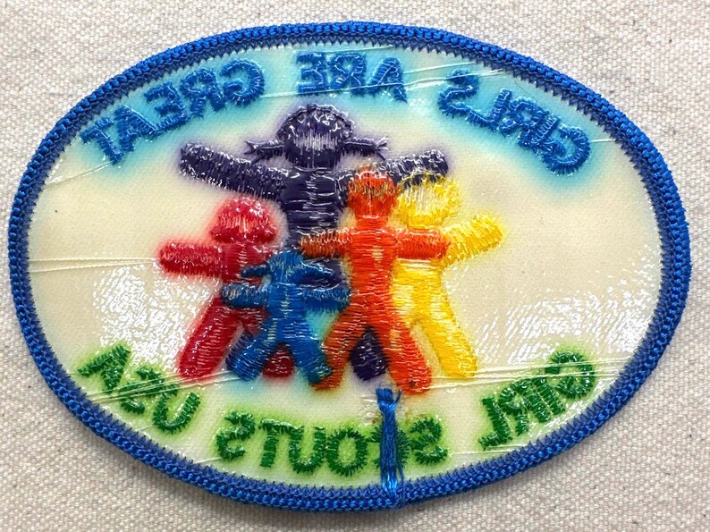 May include: Embroidered patch with a blue border and the text "GIRLS ARE GREAT" and "STUDENTS ARE US". The patch features five colourful figures in red, blue, orange, yellow, and purple.