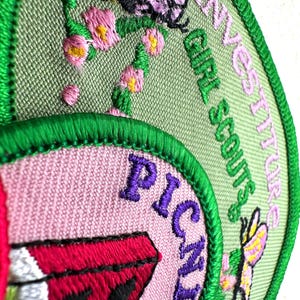 May include: Embroidered Girl Scout patches with green, pink, and purple details. One patch features a watermelon slice and the word "PICNIC". Another patch has a butterfly and the words "INVESTITURES GIRL SCOUTS".