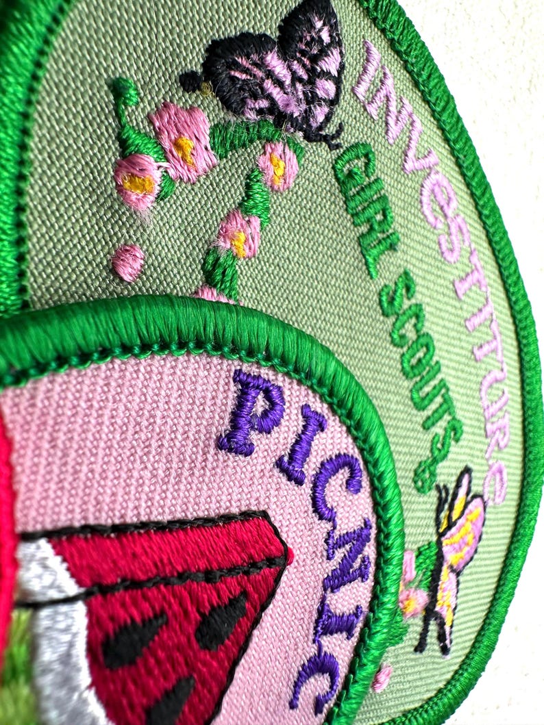 May include: Embroidered Girl Scout patches with green, pink, and purple details. One patch features a watermelon slice and the word "PICNIC". Another patch has a butterfly and the words "INVESTITURES GIRL SCOUTS".