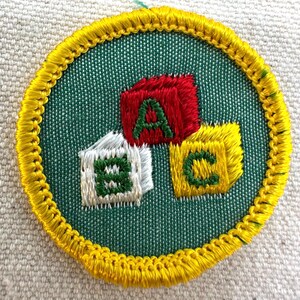 Pu&ograve; includere: Toppa ricamata con sfondo verde e bordo giallo. La toppa presenta tre blocchi colorati con le lettere A, B e C. La lettera A &egrave; rossa, B &egrave; bianca e C &egrave; gialla. Le lettere sono verdi.