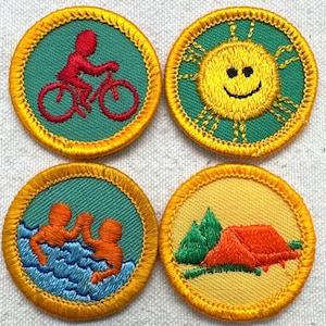 May include: Four embroidered patches with yellow borders. One shows a red figure riding a bicycle, another a smiling yellow sun, a third two orange figures swimming, and the last an orange tent and green trees.