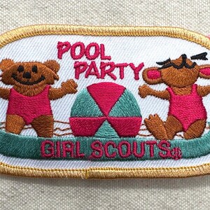 May include: Embroidered patch with a white background and gold trim. The patch features two brown bear-like characters in pink swimsuits, a beach ball, and the words "POOL PARTY GIRL SCOUTS" in pink and green.