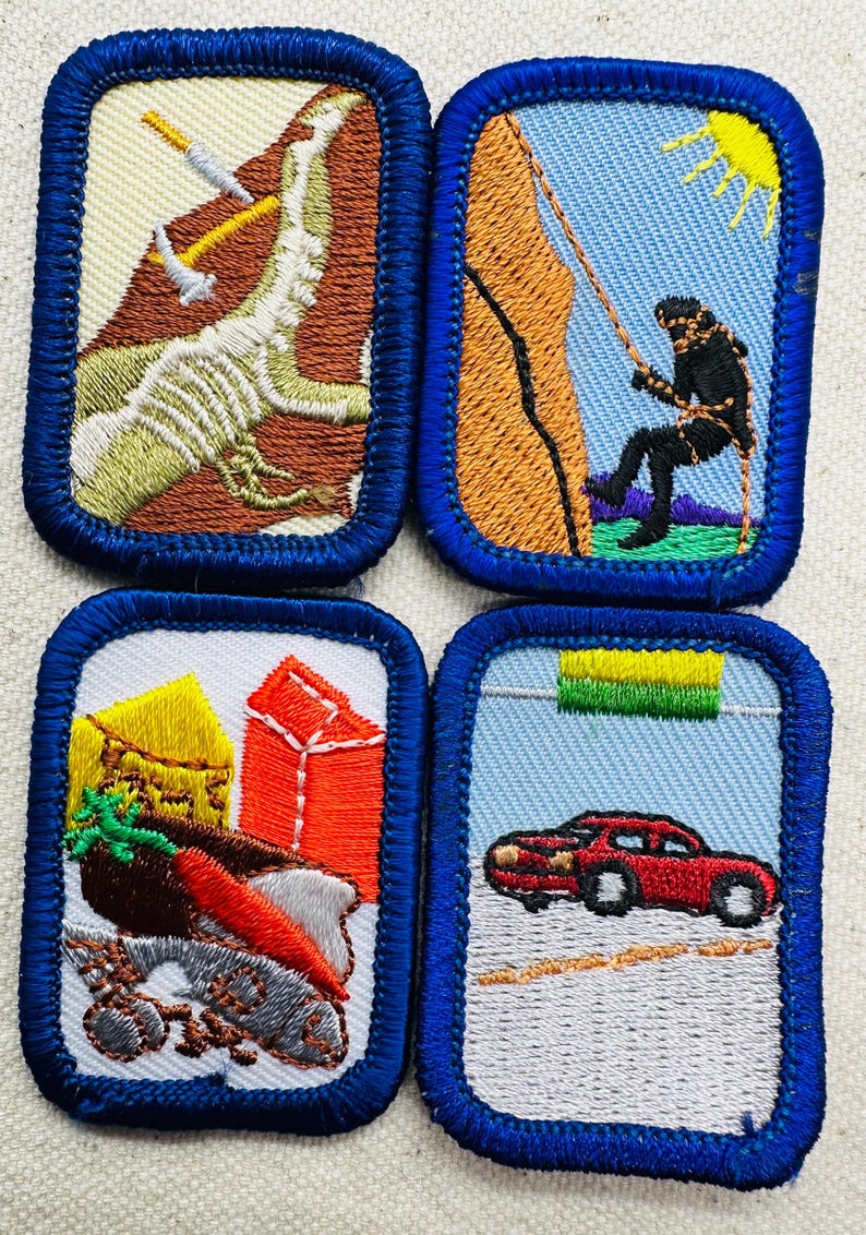 May include: Four embroidered patches with blue borders. One depicts a dinosaur skeleton with tools, another a person climbing a rock face, a third shows a cart with produce, and the last a red car.