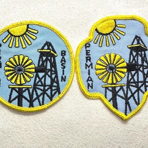 May include: Two embroidered patches featuring a light blue background with a yellow sun, a yellow windmill, and a black oil derrick. The text PERMIAN BASIN is stitched in black. One patch is circular, and the other has a scalloped, badge-like shape.