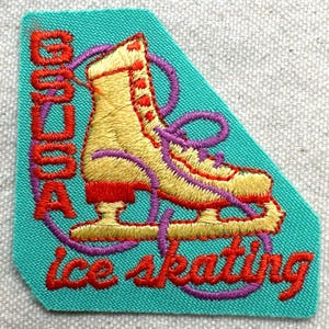 May include: Embroidered patch featuring a yellow ice skate with red accents and purple laces. The patch is teal and has the words "Good as ice skating" in red and purple thread. The patch is a fun accessory for clothing or bags.