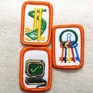 May include: Three embroidered patches with orange borders. One patch features a dollar sign, another shows colorful keys, and the third depicts a computer with a checkmark on the screen. All patches have a white background.