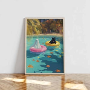 May include: A framed art print depicts a ghost and a black cat floating in a pool on inflatable rings. The ghost is in a pink ring, and the cat is in a yellow ring. The pool water is turquoise, with fallen leaves. Palm trees and a building are in the background.