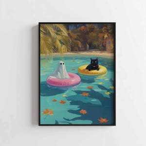 May include: A framed art print depicts a whimsical scene of a ghost and a black cat floating in a pool on inflatable rings. The ghost is in a pink ring, and the cat is in a yellow ring. Autumn leaves float in the turquoise water.