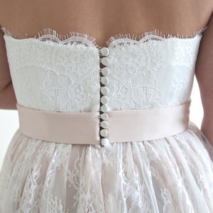 Lace wedding dress in A-line silhouette made in delicate Chantilly lace over tulle and satin under layers.