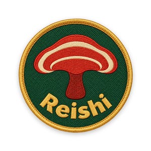 May include: A circular embroidered patch featuring a dark green background with a gold border. In the centre is a red and cream mushroom graphic. Below the mushroom, the word Reishi is embroidered in gold thread in a curved font style.