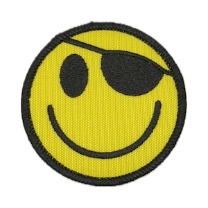 May include: Embroidered yellow smiley face patch with a black eye patch and black outline. The patch features a smiling mouth and a black eye. This patch is perfect for jackets, bags, or other fabric items.