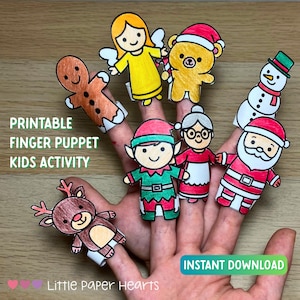 Puede incluir: Una mano que muestra marionetas de dedo imprimibles, incluyendo un hombre de jengibre, un ángel, un oso, un elfo, una abuela, un muñeco de nieve y Papá Noel. Las marionetas son coloridas y están diseñadas para una actividad infantil. El texto en la imagen dice "Printable Finger Puppet Kids Activity" y "Instant Download."