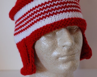 May include: A red and white knit hat with ear flaps. The hat features alternating horizontal stripes of red and white. The hat is displayed on a mannequin head.