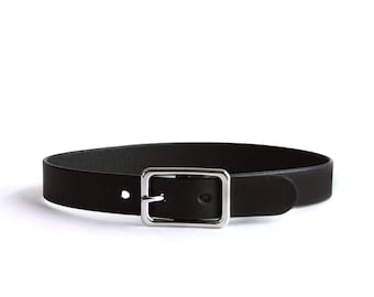 May include: A black belt featuring a smooth, matte finish and a rectangular silver-toned metal buckle. The belt strap is plain with a single prong and a matching metal loop, showcasing a clean, functional design for securing garments.