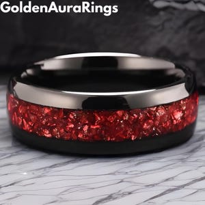以下が含まれることがあります： シルバーのバンドと鮮やかな赤色のセンターを備えた黒い指輪。 リングは研磨仕上げで、モダンなデザインです。 リングはジュエリーです。
