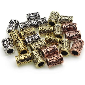 Peut inclure: Un ensemble de perles en métal avec des runes vikings et des motifs de nœuds celtiques. Les perles sont dans des tons dorés, argentés et bronze.