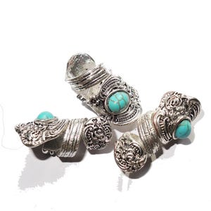 May include: Three silver rings with turquoise stones. The rings are ornate and have a vintage style.