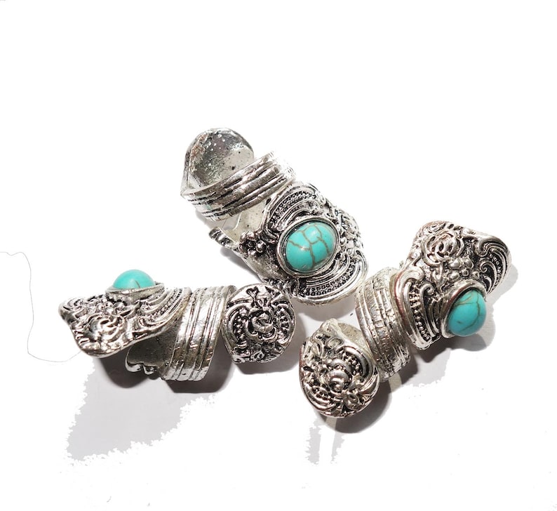 May include: Three silver rings with turquoise stones. The rings are ornate and have a vintage style.