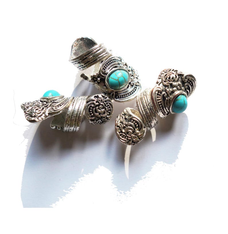 May include: Three silver rings with turquoise stones. The rings are ornate and have a vintage style.