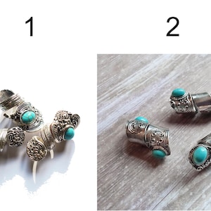May include: Two sets of silver rings with turquoise stones. The rings are ornate and have a bohemian style.