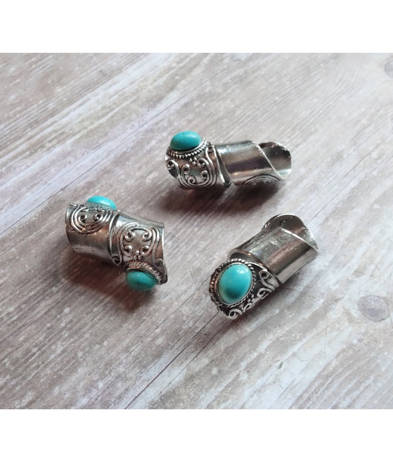 May include: Three silver rings with turquoise stones. The rings are adjustable and have a unique design.