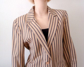 May include: A striped blazer with a tan background and dark blue and brown stripes. The blazer has a notched collar, long sleeves, and a single button closure.