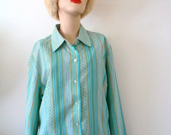 May include: A turquoise and white striped long-sleeved shirt with a button-up front and a collar. The shirt has a small geometric pattern throughout.