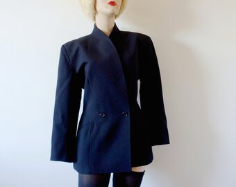 May include: A black double-breasted blazer with a long, pointed collar. The blazer is worn by a mannequin with a white fur hat.