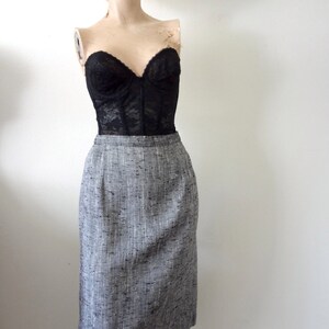Puede incluir: Una falda l&aacute;piz de tweed gris y blanco con un corpi&ntilde;o de encaje negro.