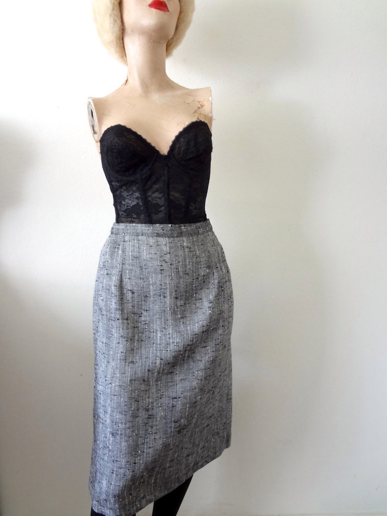 Puede incluir: Una falda l&aacute;piz de tweed gris y blanco con un corpi&ntilde;o de encaje negro.