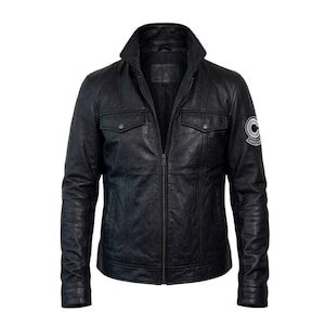 Könnte beinhalten: Schwarze Lederjacke mit Stehkragen, zwei Brusttaschen und Reißverschluss. Mit einem Capsule Corp-Aufnäher auf dem linken Oberarm. Die Jacke hat ein klassisches, tailliertes Design.