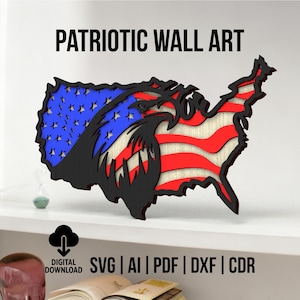 May include: Patriotic wall art in the shape of the United States, featuring the American flag and an eagle design. The artwork is made of layered wood with red, white, blue, and black colors. The text "PATRIOTIC WALL ART" is displayed above the art.