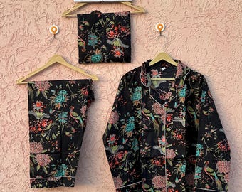 Könnte beinhalten: Ein schwarzer Schlafanzug mit einem lebendigen Blumen- und Vogelmuster in Türkis, Pink und Orange. Das Set besteht aus einem langärmeligen Hemd mit Knopfleiste und Kragen sowie einer passenden Hose, präsentiert mit einem Schild ETSY SHOP SEHANDICRAFTS.
