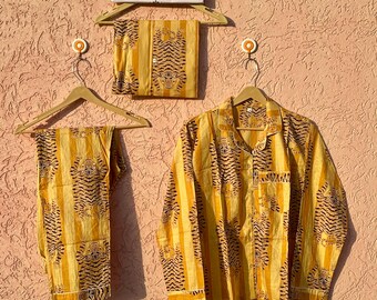 Könnte beinhalten: Ein gelbes Pyjama-Set mit Tigermuster und vertikalen Streifen. Das Set besteht aus einem langärmeligen, geknöpften Hemd mit Kragen und Brusttasche sowie einer passenden Hose. Ein Schild darüber trägt die Aufschrift ETSY SHOP SEHANDICRAFTS.