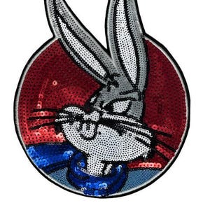 Op de afbeelding: Een Bugs Bunny-patch met een rode paillettenachtergrond. Het cartoonkonijn is grijs en wit met zwarte accenten en draagt een blauwe kraag. De patch is cirkelvormig met een zwarte rand.