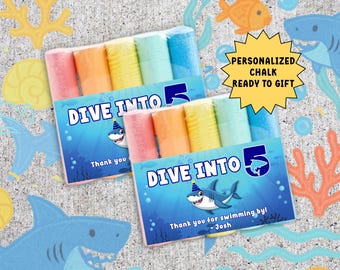 May include: Party favor sets with colorful chalk sticks. Each box features a shark graphic and the text "Dive Into 5". The boxes are personalized and ready to gift. The top of the image reads "Dive Into Five Party Favor".