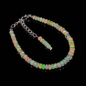 Puede incluir: Una pulsera de ópalo con cadena y cierre de plata. La pulsera presenta pequeñas cuentas de ópalo facetadas en tonos blanco, rosa, verde y amarillo. La pulsera mide aproximadamente 18 cm de largo.