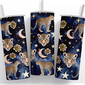 May include: Three stainless steel tumblers with a celestial design. The navy blue background features gold stars, moons, and roses, along with leopard illustrations. Each tumbler has a silver straw and a white lid.