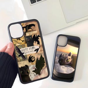 May include: Two black phone cases with dragon-themed designs. One case features a collage with the text "Night Fury" and dragon illustrations. The other case shows a dragon looking out of a window with a sunset background.