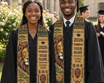 May include: Two graduates in black gowns and caps, smiling at the camera. They wear custom graduation stoles with a lion's head, the text "Class of 2026", "Your Name", and "School Name". Each holds a rolled diploma.