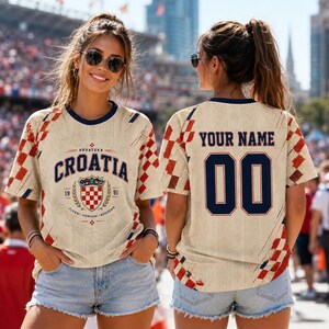 A woman wearing a Croatia jersey with the number 00, standing in front of a crowd at a sporting event.