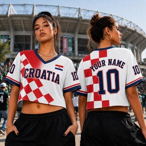 A woman wearing a red and white Croatia soccer jersey with the number 10, standing in front of a stadium.