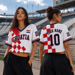 Two women wearing white and red Croatia soccer jerseys with the number 10, posing in front of a stadium.