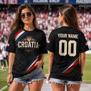 A woman wearing a black t-shirt with the word "Croatia" printed on it, standing in front of a crowd at a sports event.