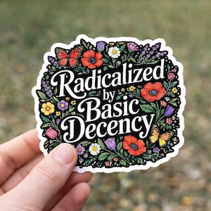 May include: A sticker with the text "Radicalized by Basic Decency" in a black, ornate font. The sticker is surrounded by a floral border with red poppies, butterflies, and other colorful flowers.