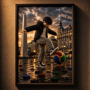 May include: A framed wall art print depicting a block-built figure in a black jacket and gray pants kicking a multicolored soccer ball. The scene is set in a city square with the Obelisco de Buenos Aires, an Argentine flag, and scattered blocks.