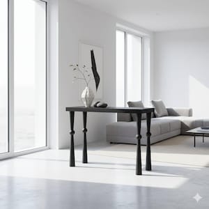 Puede incluir: Una consola negra con una tapa rectangular y patas decorativas. La mesa está en un salón moderno, con un jarrón y piedras decorativas encima. La altura de la mesa es de aproximadamente 76 cm.